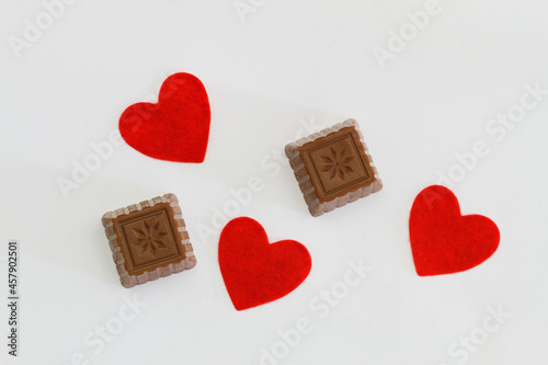 Obraz na płótnie Milky chocolates and red hearts on white background
w salonie
