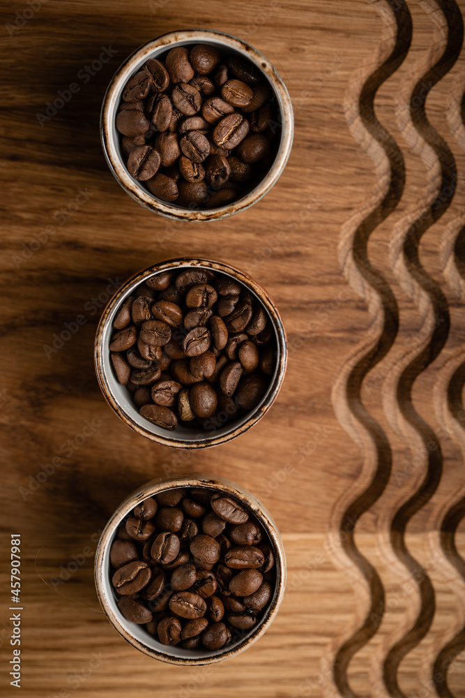 coffee beans in cups on a wooden background with a pattern. High quality photo coffee beans in cups on a wooden background with a pattern. High quality photo