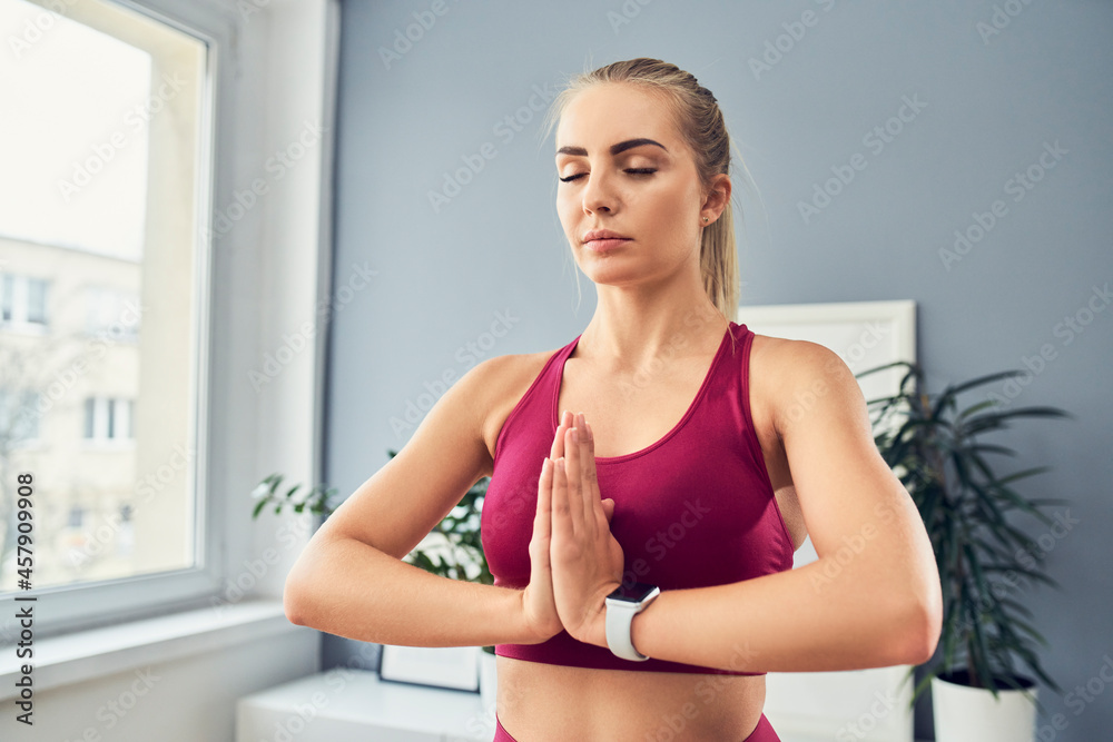 Sporty woman doing meditation, yoga exercise at home