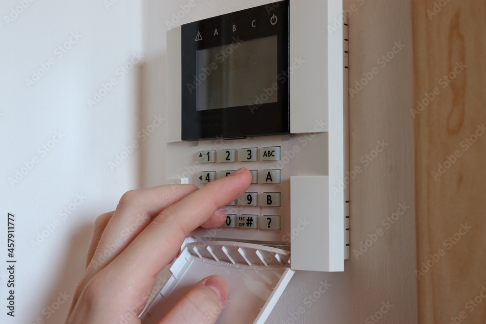 Hand on keyboard of modern house security system. Property protection by alarm. Hand on keyboard of modern house security system. Property protection by alarm.