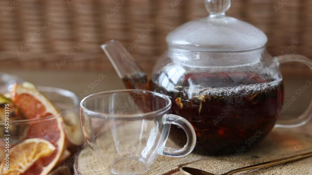 a glass teapot with black tea. Assorted Dried Fruits close-up. Snacks from dried fruits. dried apples, oranges, lemons, kiwi, pineapple.