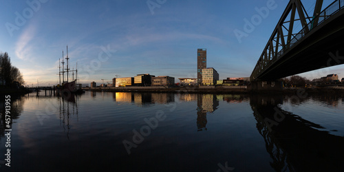 panorama of the Überseestadt, Bremen, Germany, a commercial district with modern architecture at the river Weser at sunset