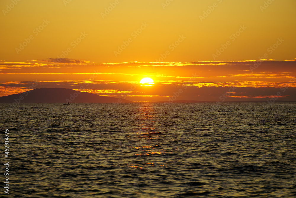 Golden hour on the wavy sea at the fiery sunset