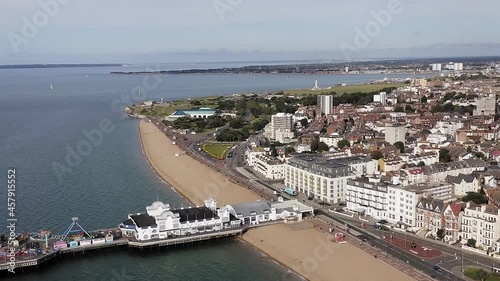 Southsea Victorian Seafront and Pier with a long stretch of beach and Southsea Common in view. Aerial footage.