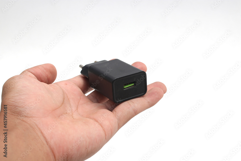Black Cell Phone Charger Adapter with a green micro USB quick charge on hand isolated on white background Black Cell Phone Charger Adapter with a green micro USB quick charge on hand isolated on white background