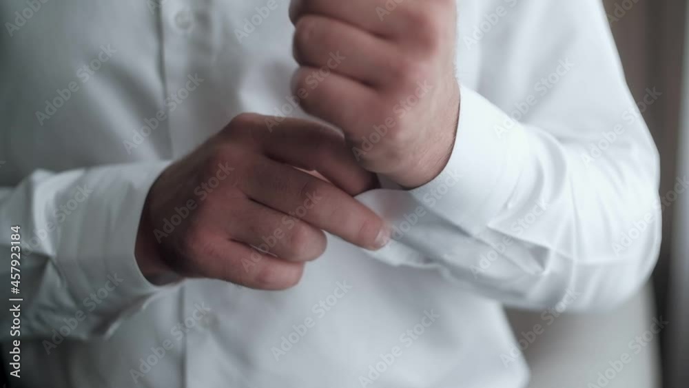Buttoning a suit. Stylish man in a suit fastening buttons on his suit preparing to go out. Close up Buttoning a suit. Stylish man in a suit fastening buttons on his suit preparing to go out. Close up