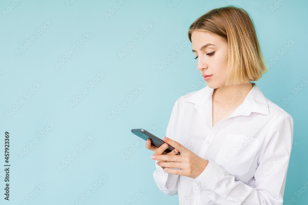 Digital lifestyle. Office woman. Mobile technology. Advertising background. Concentrated lady scrolling smartphone isolated blue copy space. Digital lifestyle. Office woman. Mobile technology. Advertising background. Concentrated lady scrolling smartphone isolated blue copy space.