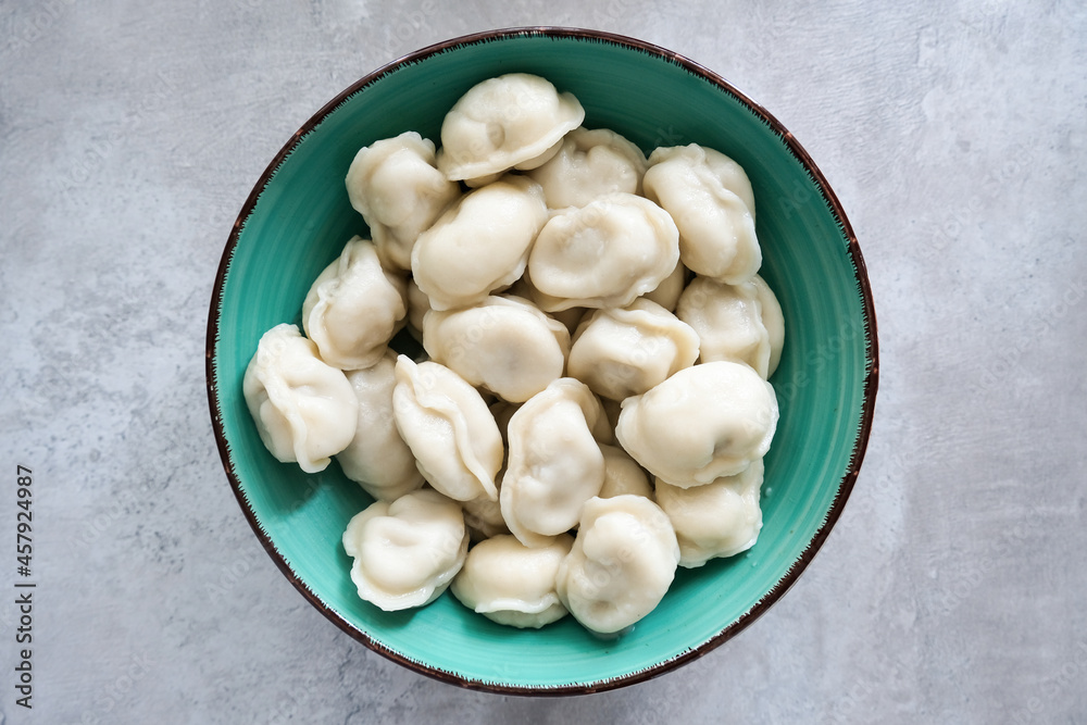 Tasty meat dumplings in green plate on a table, russian pelmeni Tasty meat dumplings in green plate on a table, russian pelmeni
