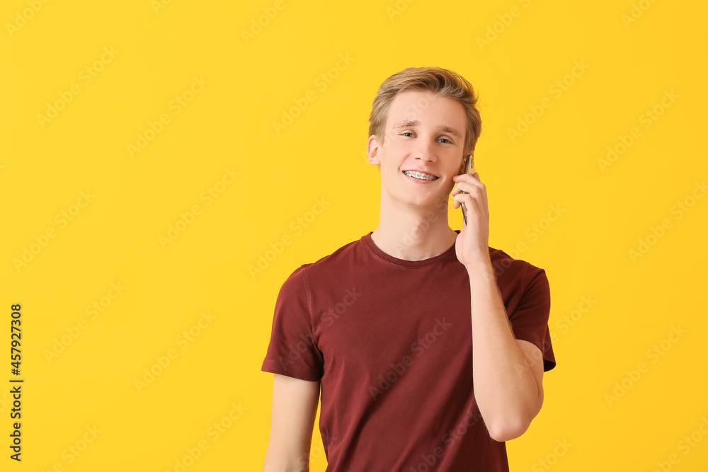 Handsome man with dental braces talking by mobile phone on color background Handsome man with dental braces talking by mobile phone on color background