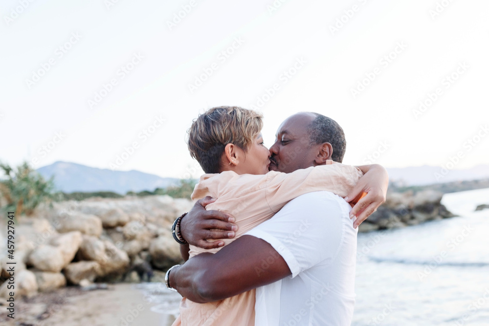 Multiracial couple kissing at the beach.Love lifestyle concept . Multiracial couple kissing at the beach.Love lifestyle concept .