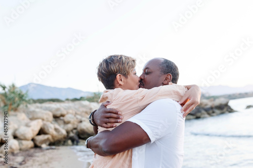 Multiracial couple kissing at the beach.Love lifestyle concept .