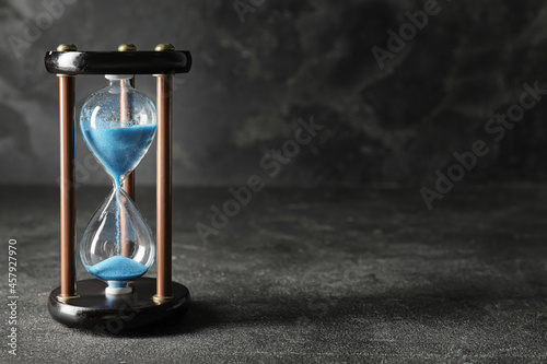 Stylish hourglass on dark background. Deadline concept