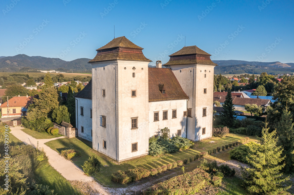 Aerial view of medieval Renaissance mansion with two twin towers and garden in Diviaky, Divek near Turčianske Teplice in Slovakia with blue sky background
