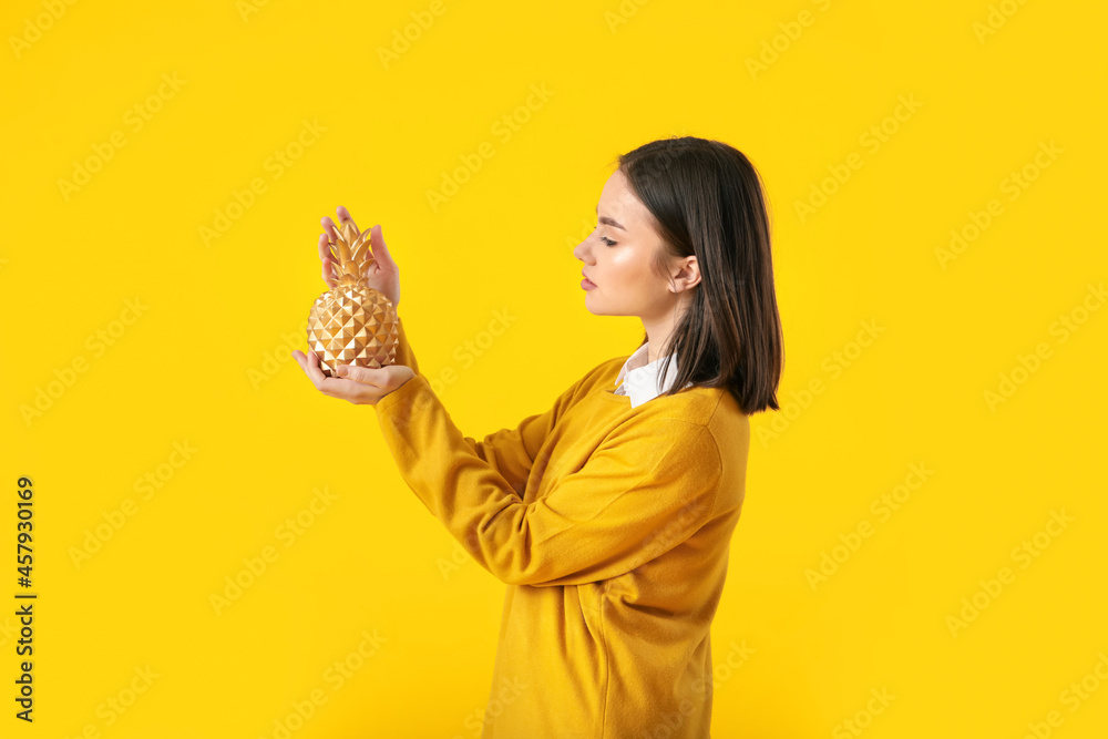 Beautiful young woman with decorative pineapple on yellow background Beautiful young woman with decorative pineapple on yellow background