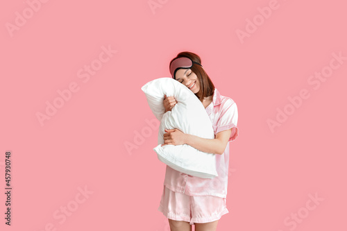 Young woman hugging pillow ...
