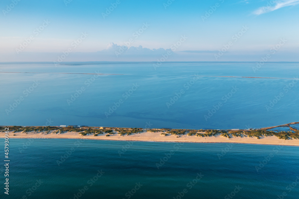 Long spit with beautiful sandy beach between sea and liman, aerial view from drone.