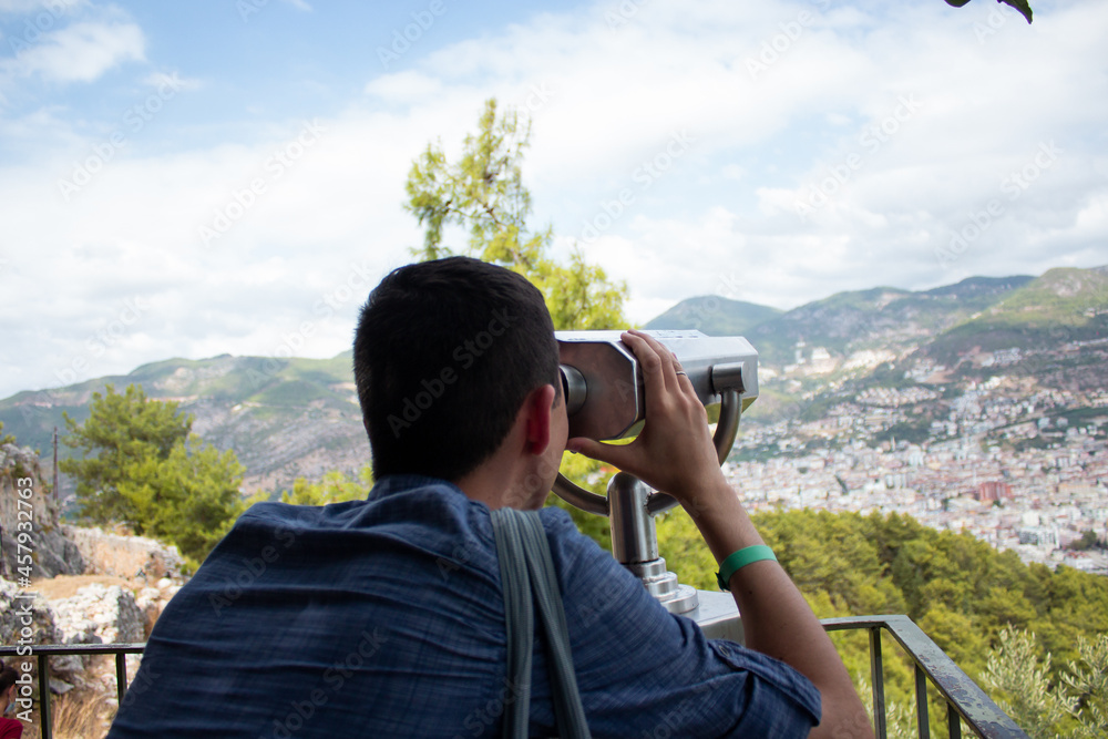 A young guy looks through the observation binoculars Turkey, Kyzyl Kul
