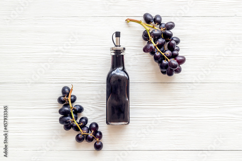 Bottle of balsamic vinegar with bunch of fresh grapes photo