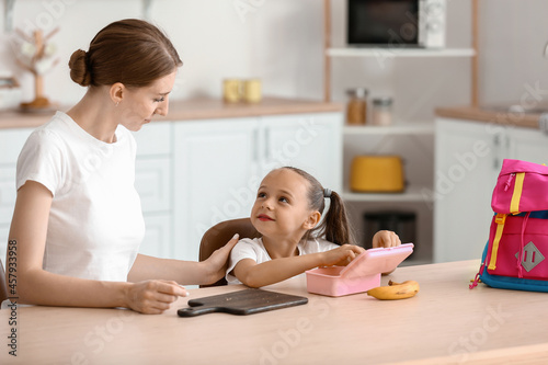 Mother feeding her little d...