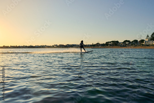 A male boy surfing towards the bay from the beach