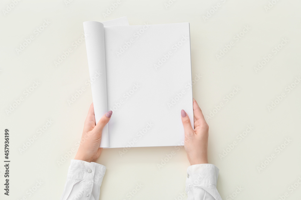 Female hands with blank magazine on light background Female hands with blank magazine on light background