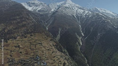 Awesome panoramic flight above lost in mountains secluded Ghyaru village nearby snowy Pisang Peak, Nepal photo