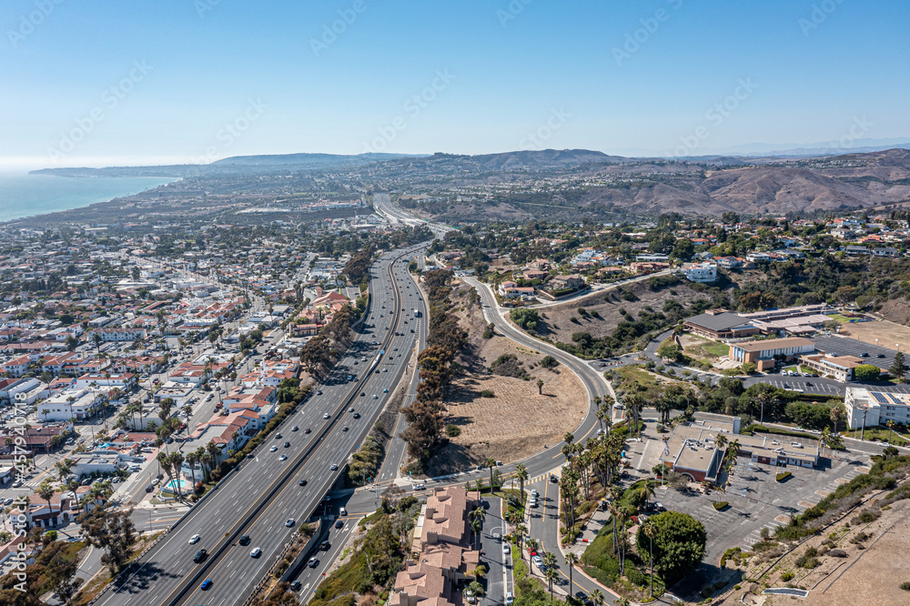 Aerial view of a coastal freeway cutting through a suburban neighborhood