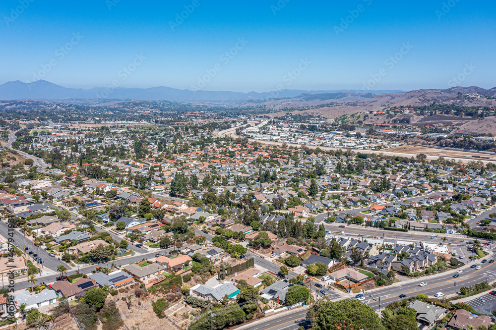 Aerial view of a coastal southern California community surrounded by hills on a clear sunny day