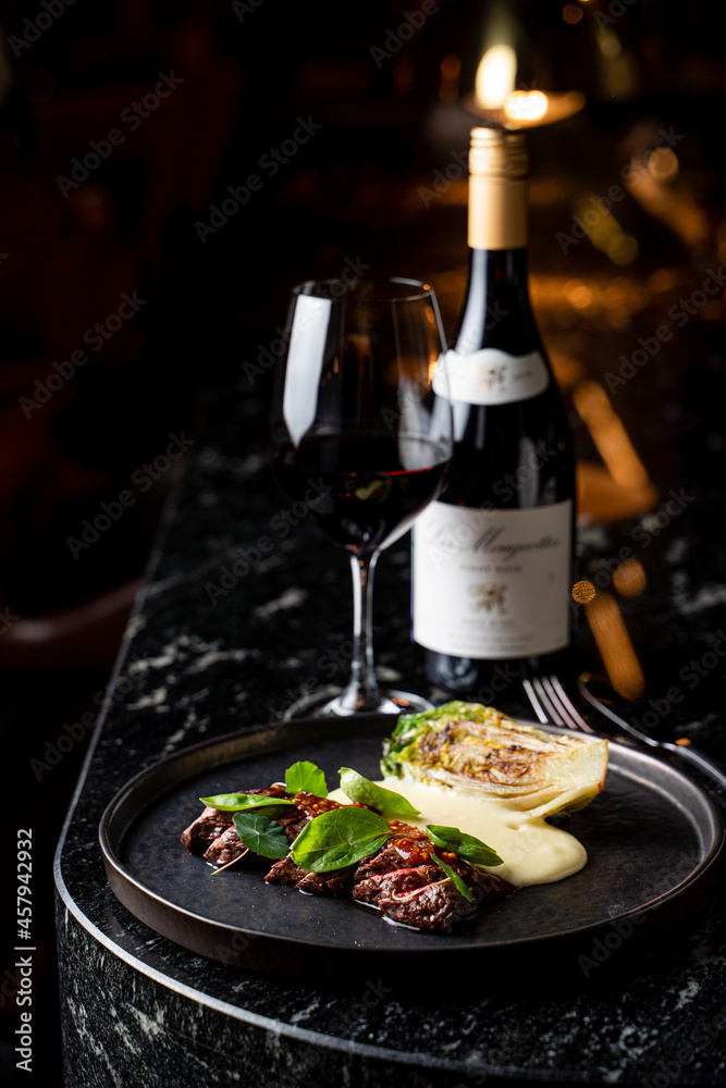 Raw steak and a glass of red wine on dark marble table Raw steak and a glass of red wine on dark marble table
