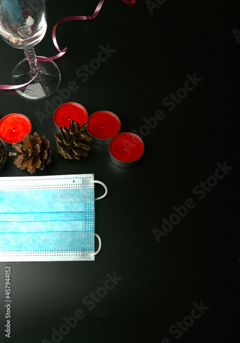 Small festive lighted candles with fir cones and a champagne glass.