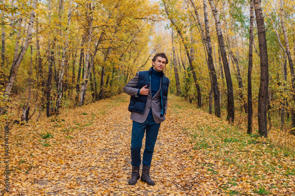 Tall handsome man walking in the autumn alley Tall handsome man walking in the autumn alley