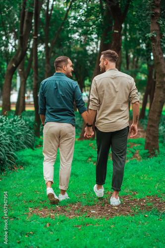 gay couple walking backwards holding hands