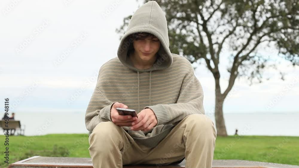 Teenager boy with cell phone on natural background, mobile communication, digital technology. Teenager boy with cell phone on natural background, mobile communication, digital technology.