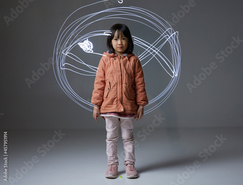 Cute Asian little girl playing with light and shadow indoors