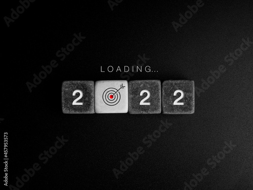 Loading to the 2022 year concept. Word and year numbers on black and white cube blocks with target icon sign in the progress bar on dark. Business update, upgrade Ideas, creative thinking concepts.