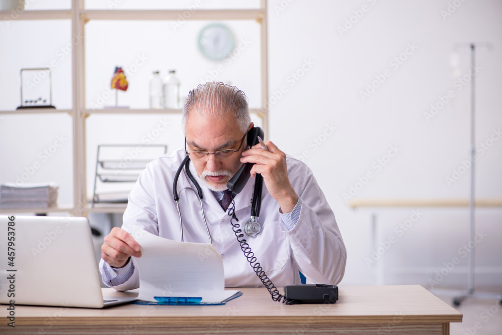 Old male doctor in telemedicine concept