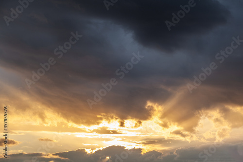 Colorful sunset or sunrise in the sky. The sun's rays are visible through the clouds. The sky and clouds are painted in different delicate colors. Beautiful background.