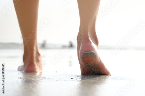 Asian tourist female legs She was walking on a beautiful sandy beach. and she was about to walk into the sea