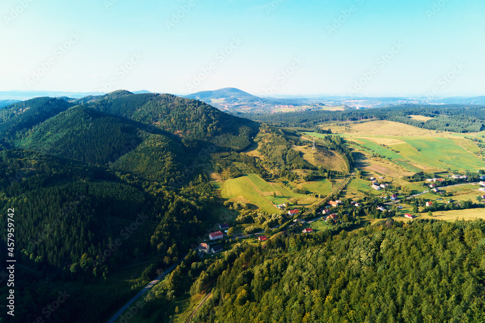 Village near mountain and agricultural fields at sunset. Nature landscapem aerial view