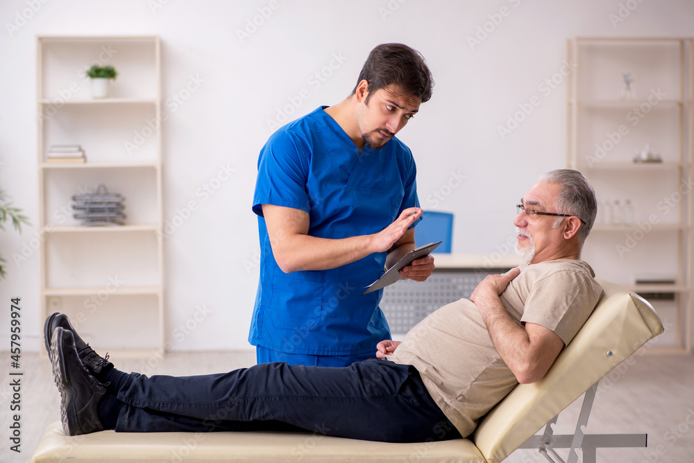 Old male patient visting young male doctor Old male patient visting young male doctor