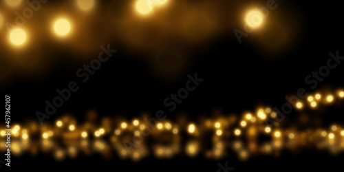 Golden particle dust on black. Abstract luxury background with defocused glitter lights. 