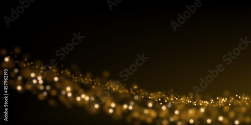 Golden particle dust on black. Abstract luxury background with defocused glitter lights. 