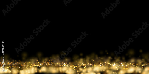 Golden particle dust on black. Abstract luxury background with defocused glitter lights. 