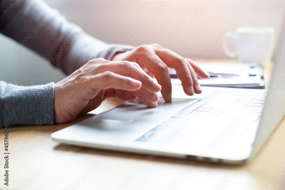 A man using and typing keyboard of laptop computer communicates on internet technology with paperwork on office desk. Workplace, Businessman professional busy working on new job project idea. A man using and typing keyboard of laptop computer communicates on internet technology with paperwork on office desk. Workplace, Businessman professional busy working on new job project idea.