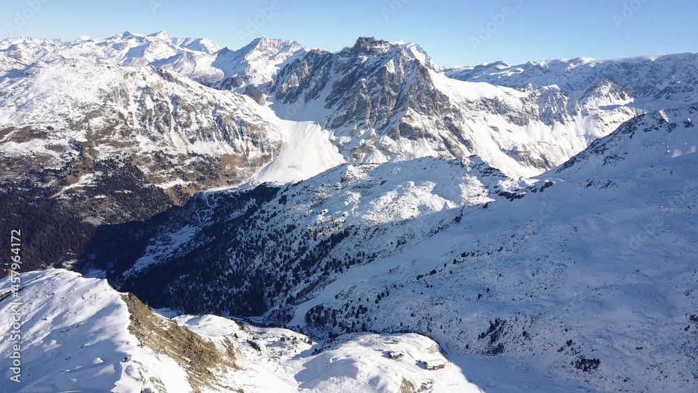 Aerial flight above stunning Alps Top Peak. 
Drone view above High mountain peaks sharp cliffs with blue sky , Val Thorens, France
