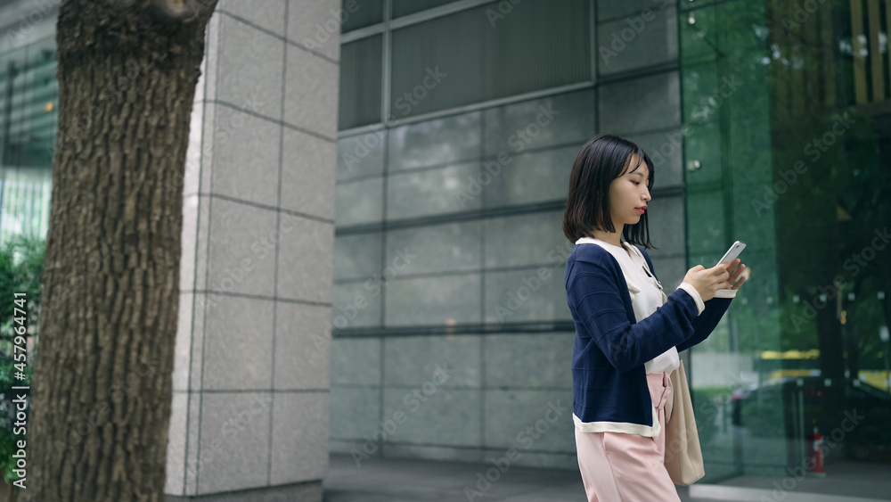 スマホを持って街を歩く女性 スマホを持って街を歩く女性