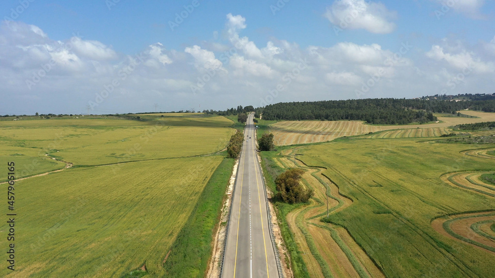 Straight road between green fields, Aerial view
drone view from Israel, nachshon junction ,2021

