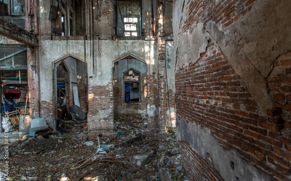 The abandoned building with visible bricks texture was left to deteriorate over time and visible parts of structural elements and ruins. Traditional Architecture style, Selective focus.