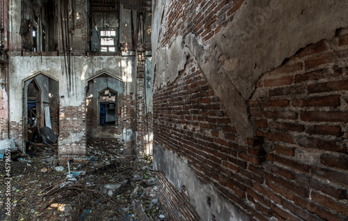 The abandoned building with visible bricks texture was left to deteriorate over time and visible parts of structural elements and ruins. Traditional Architecture style  Selective focus.