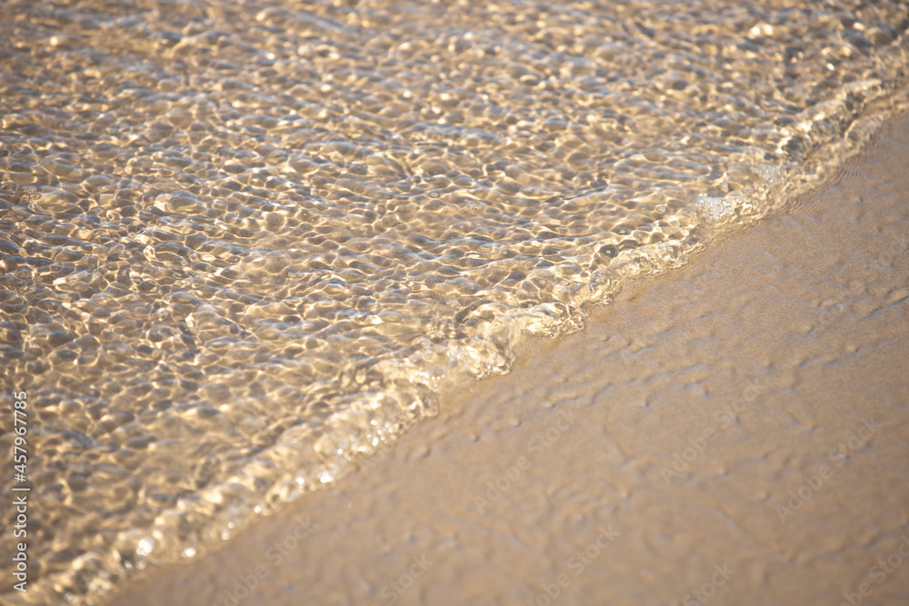 The influx of water in a thin layer on the sandy shore. The influx of water in a thin layer on the sandy shore.